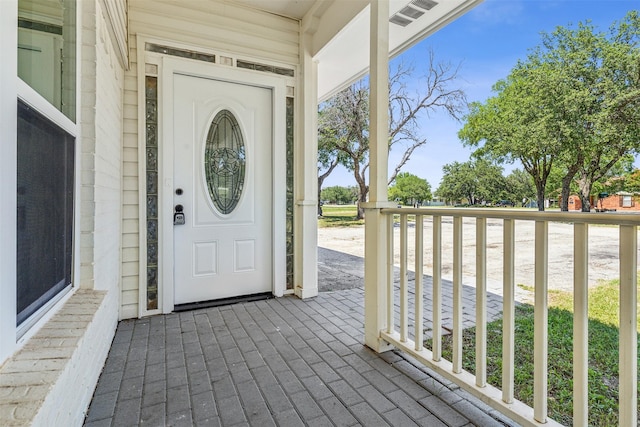 property entrance with covered porch and visible vents