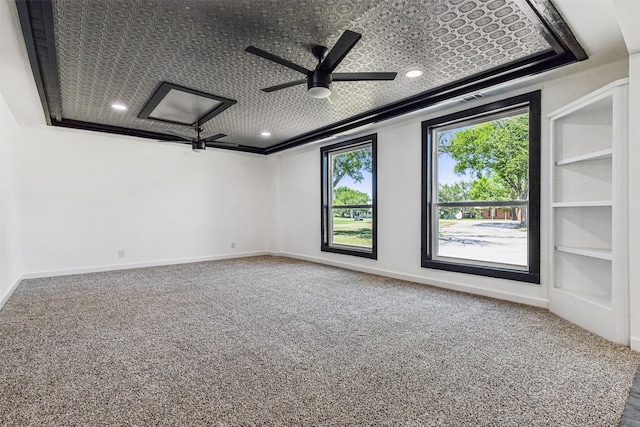 carpeted spare room with recessed lighting, built in shelves, baseboards, and ceiling fan