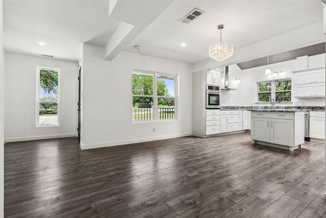 kitchen with visible vents, dark wood-type flooring, a notable chandelier, open floor plan, and stainless steel oven