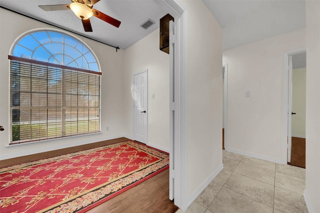 tiled foyer entrance featuring visible vents, baseboards, and ceiling fan