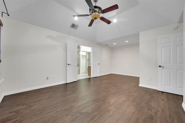 unfurnished bedroom with dark wood-style floors, visible vents, baseboards, ceiling fan, and vaulted ceiling