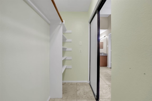 walk in closet with light tile patterned floors