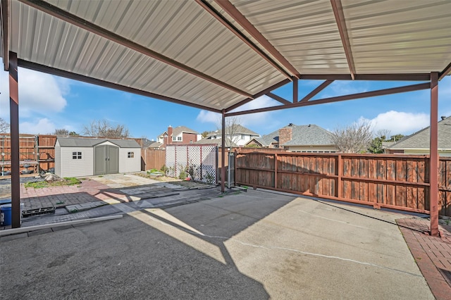 view of patio with an outbuilding, a residential view, a storage shed, and a fenced backyard