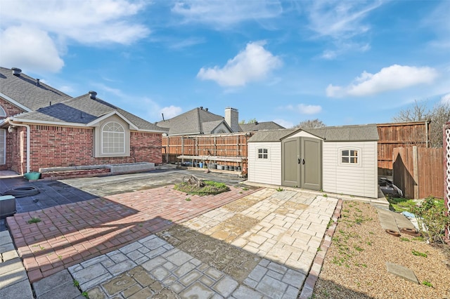 view of patio with an outbuilding, a shed, and a fenced backyard