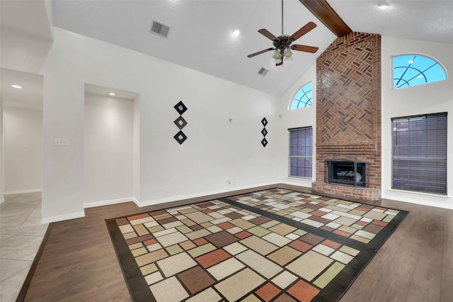 unfurnished living room featuring visible vents, high vaulted ceiling, ceiling fan, and wood finished floors