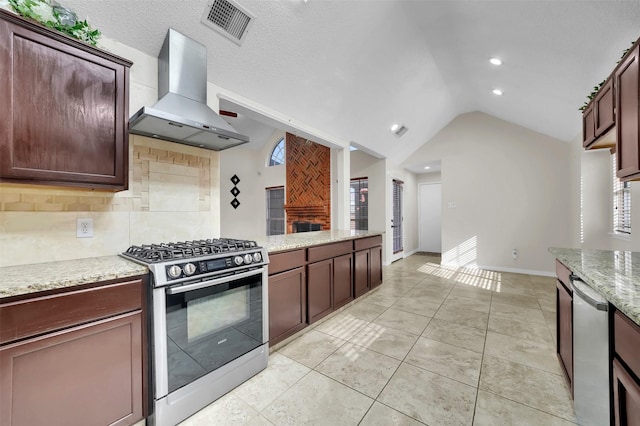 kitchen featuring visible vents, backsplash, appliances with stainless steel finishes, wall chimney exhaust hood, and lofted ceiling