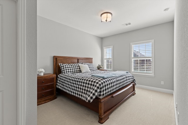 carpeted bedroom featuring visible vents and baseboards