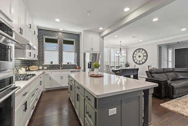 kitchen with tasteful backsplash, appliances with stainless steel finishes, open floor plan, and dark wood finished floors