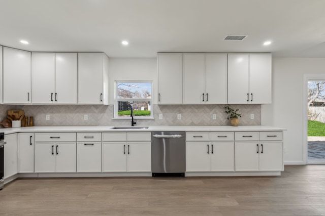 kitchen with visible vents, a sink, light countertops, white cabinetry, and stainless steel dishwasher