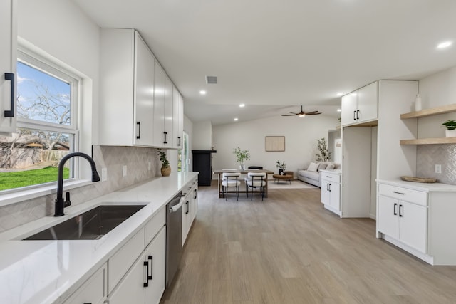 kitchen featuring a sink, light wood finished floors, dishwasher, ceiling fan, and vaulted ceiling