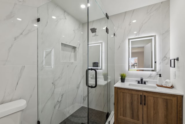 full bath with a marble finish shower, toilet, tile walls, and vanity