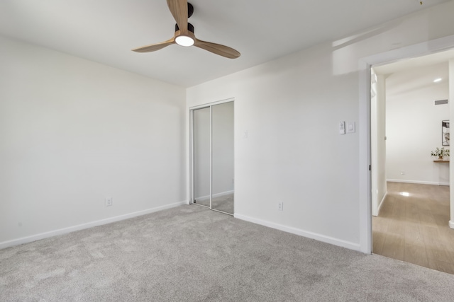 unfurnished bedroom featuring a ceiling fan, baseboards, a closet, and carpet floors