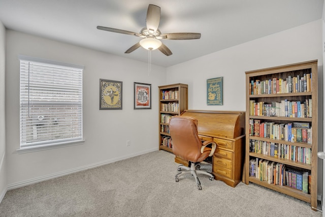 carpeted home office featuring baseboards and a ceiling fan