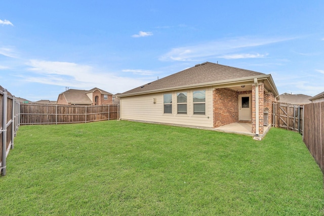 back of property with a patio area, a yard, a fenced backyard, and brick siding