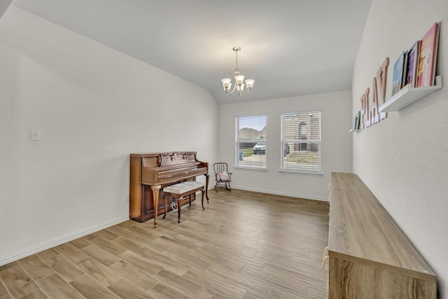 sitting room featuring lofted ceiling, a notable chandelier, baseboards, and light wood-type flooring