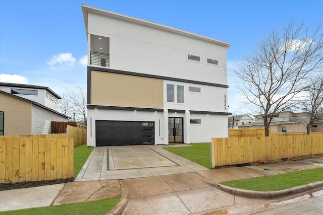 back of property featuring a garage, driveway, and fence