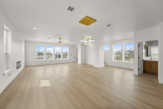 unfurnished living room with visible vents, heating unit, and plenty of natural light