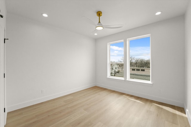 spare room featuring a ceiling fan, recessed lighting, baseboards, and light wood-type flooring