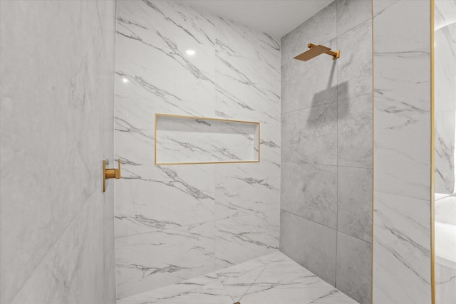 bathroom featuring a marble finish shower