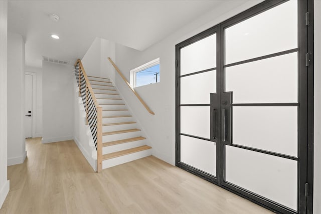 stairs with recessed lighting, visible vents, baseboards, and wood finished floors