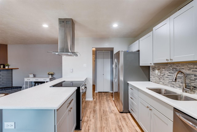 kitchen with a sink, appliances with stainless steel finishes, island range hood, and light countertops