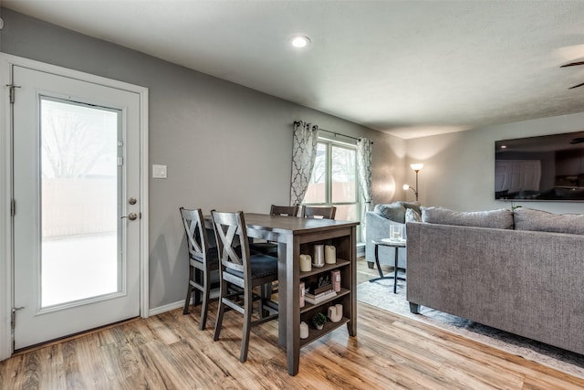 dining room featuring a ceiling fan, baseboards, and light wood finished floors