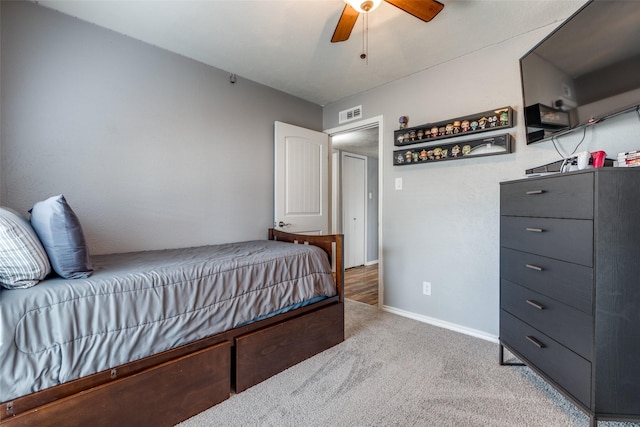 carpeted bedroom with visible vents, baseboards, and a ceiling fan