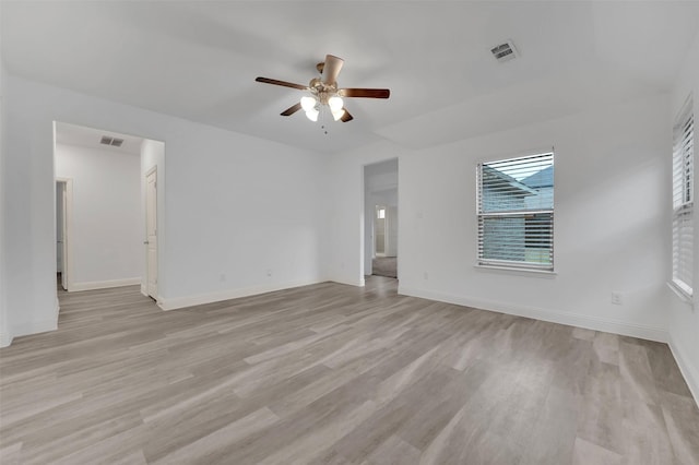 empty room with light wood finished floors, visible vents, and a ceiling fan