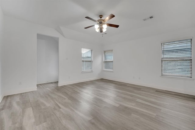 unfurnished room with light wood finished floors, visible vents, baseboards, and a ceiling fan