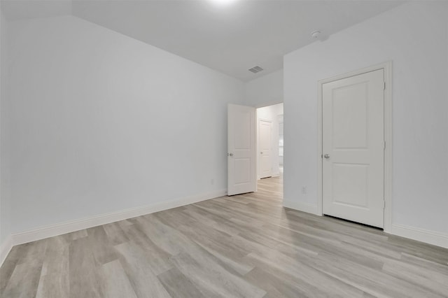 spare room featuring visible vents, light wood-style flooring, and baseboards