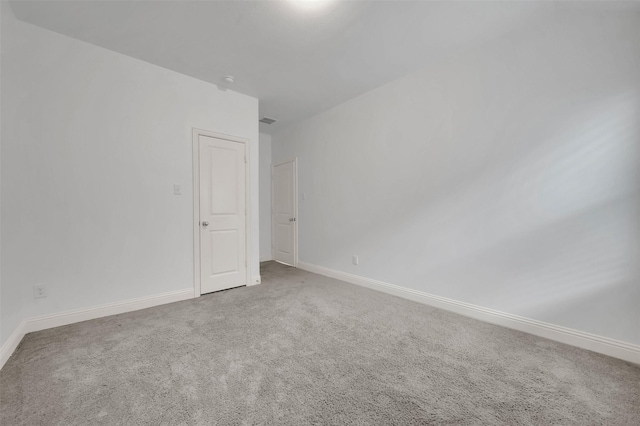 spare room featuring baseboards and carpet floors