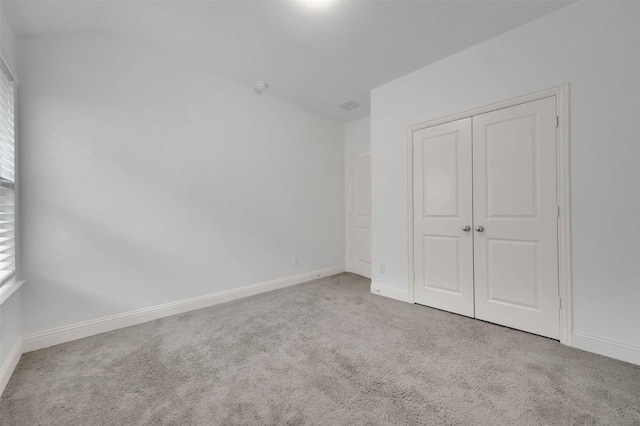 unfurnished bedroom with a closet, baseboards, visible vents, and carpet flooring