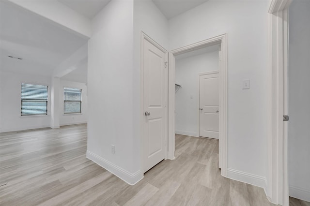 hall featuring light wood-style floors and baseboards