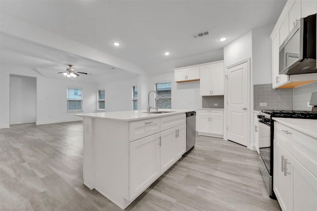 kitchen featuring tasteful backsplash, visible vents, appliances with stainless steel finishes, a ceiling fan, and a sink