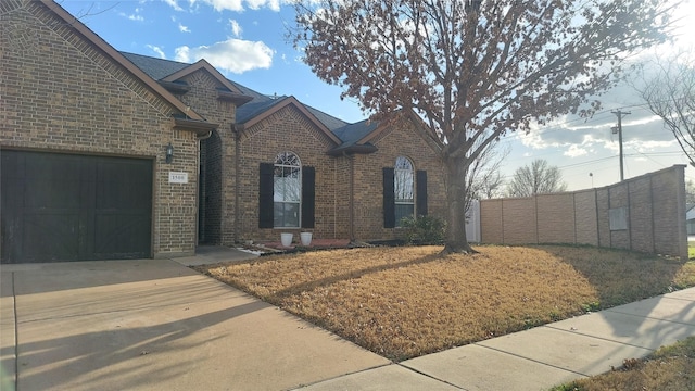 view of front of house featuring concrete driveway, brick siding, and a shingled roof