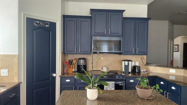 kitchen featuring electric range, visible vents, dark stone countertops, stainless steel microwave, and decorative backsplash