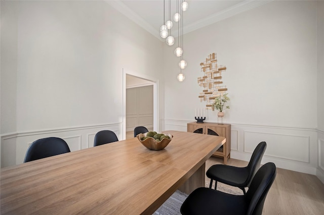 dining room with crown molding and wainscoting