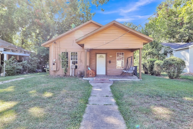 bungalow-style home with a front yard and covered porch