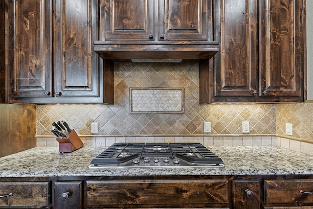 117 Birdie Dr, Lipan, TX 76462 - kitchen featuring stainless steel gas cooktop, dark brown cabinets, light stone countertops, and decorative backsplash