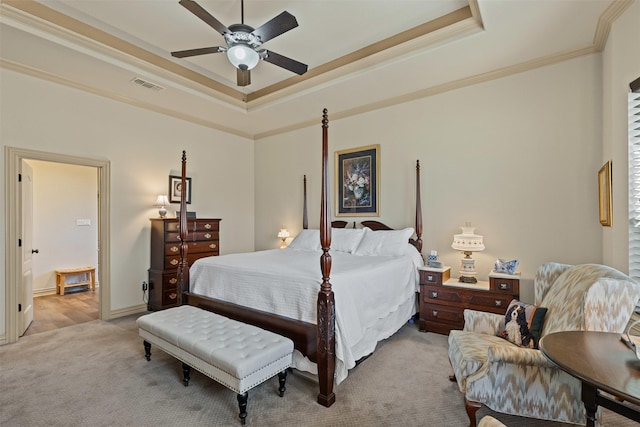 bedroom featuring a tray ceiling, crown molding, light colored carpet, and visible vents