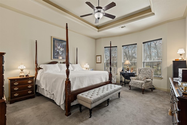 carpeted bedroom featuring visible vents, a ceiling fan, crown molding, and a tray ceiling