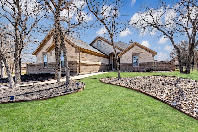 view of front of property with brick siding, stone siding, a chimney, and a front yard