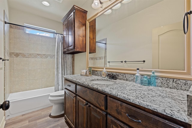 bathroom with shower / bathtub combination with curtain, toilet, vanity, and wood finished floors