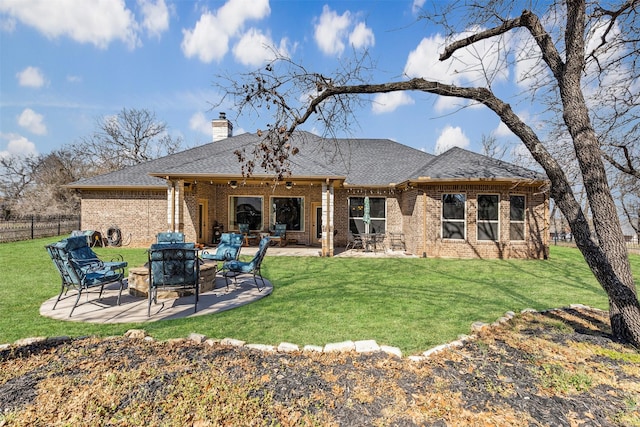 back of property featuring brick siding, a lawn, a patio, and fence