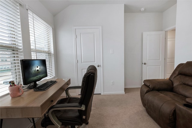 home office with lofted ceiling, light colored carpet, and baseboards