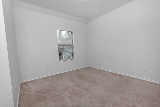 carpeted empty room featuring baseboards