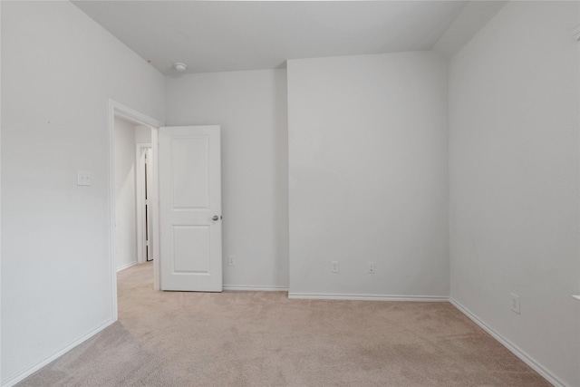 empty room with baseboards and light carpet