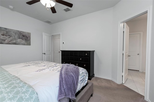 carpeted bedroom featuring tile patterned floors, visible vents, baseboards, and ceiling fan