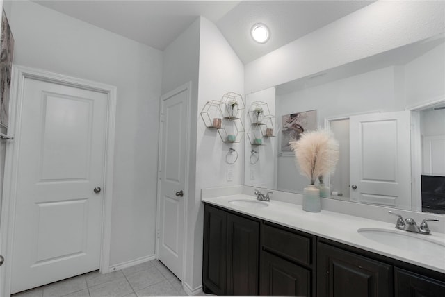 full bathroom with a sink, lofted ceiling, double vanity, and tile patterned flooring