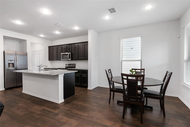 kitchen featuring visible vents, an island with sink, recessed lighting, dark wood-style flooring, and stainless steel appliances